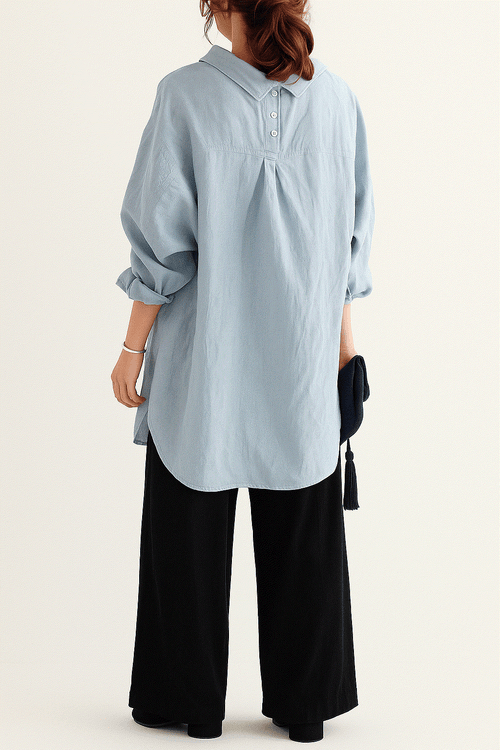Woman wearing a light blue linen-cotton blend oversized shirt and black high-waist palazzo pants from the Linen Breeze Set.