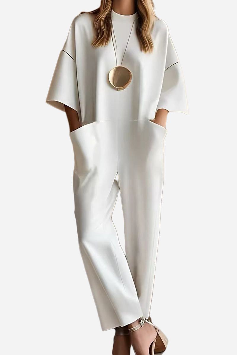 Serene minimalist white pocket jumpsuit with loose fit and short sleeves