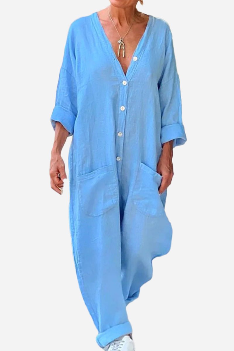 Light blue relaxed jumpsuit with button-front, deep V neckline, wide legs, and rolled-up sleeves.