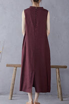 Back view of a sleeveless maroon Sunrise Market 100 linen midi dress with button details on the upper back and a center slit at the hem