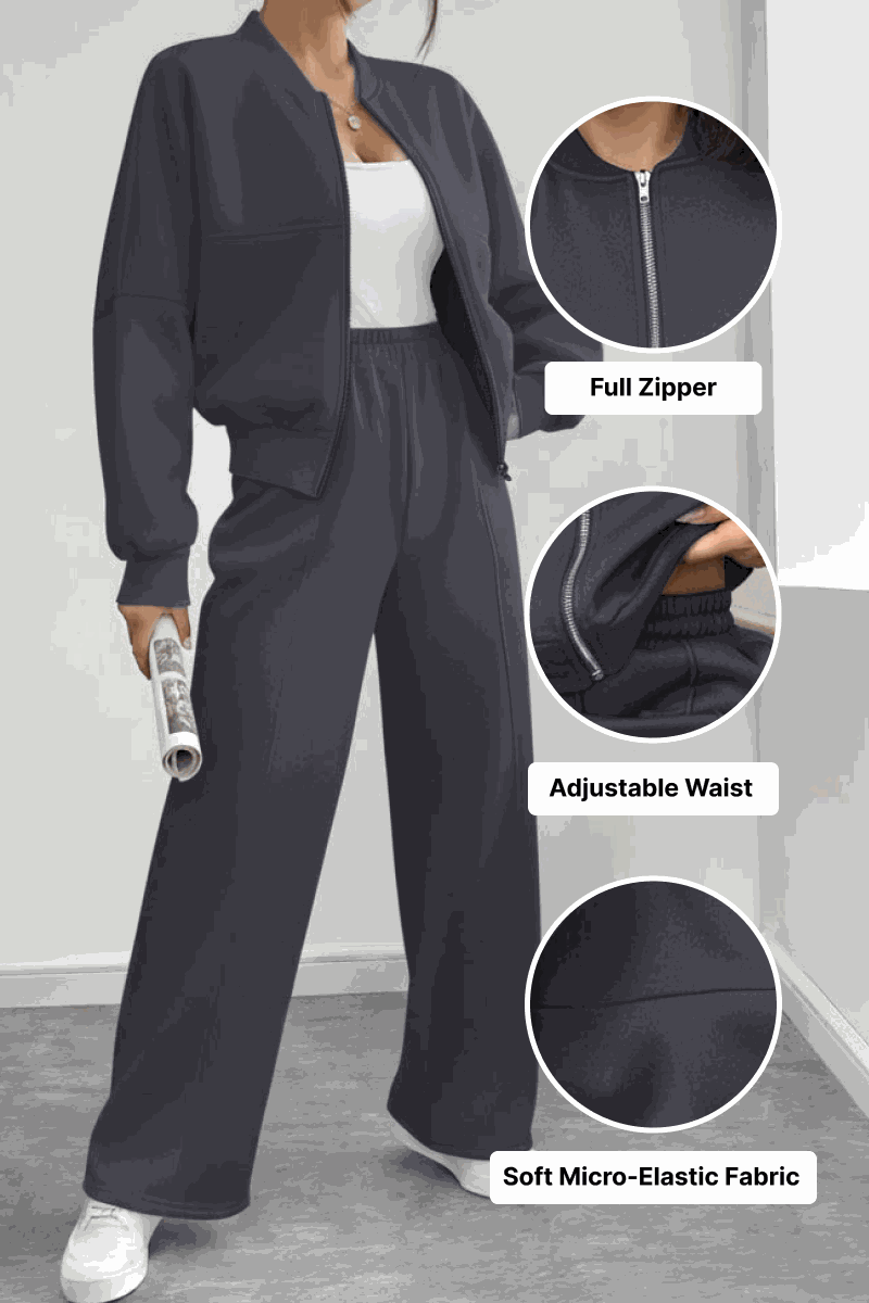 The Voyager Zip Set in black with full zipper jacket and adjustable waist wide-leg joggers in soft micro-elastic fabric, styled with white sneakers.