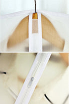 Close-up of waterproof dustproof clothing cover hanging on wooden hanger with zipper and hook closure features