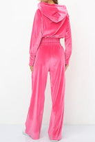 Back view of bright pink velour tracksuit with cropped hoodie and high-waist pants on model
