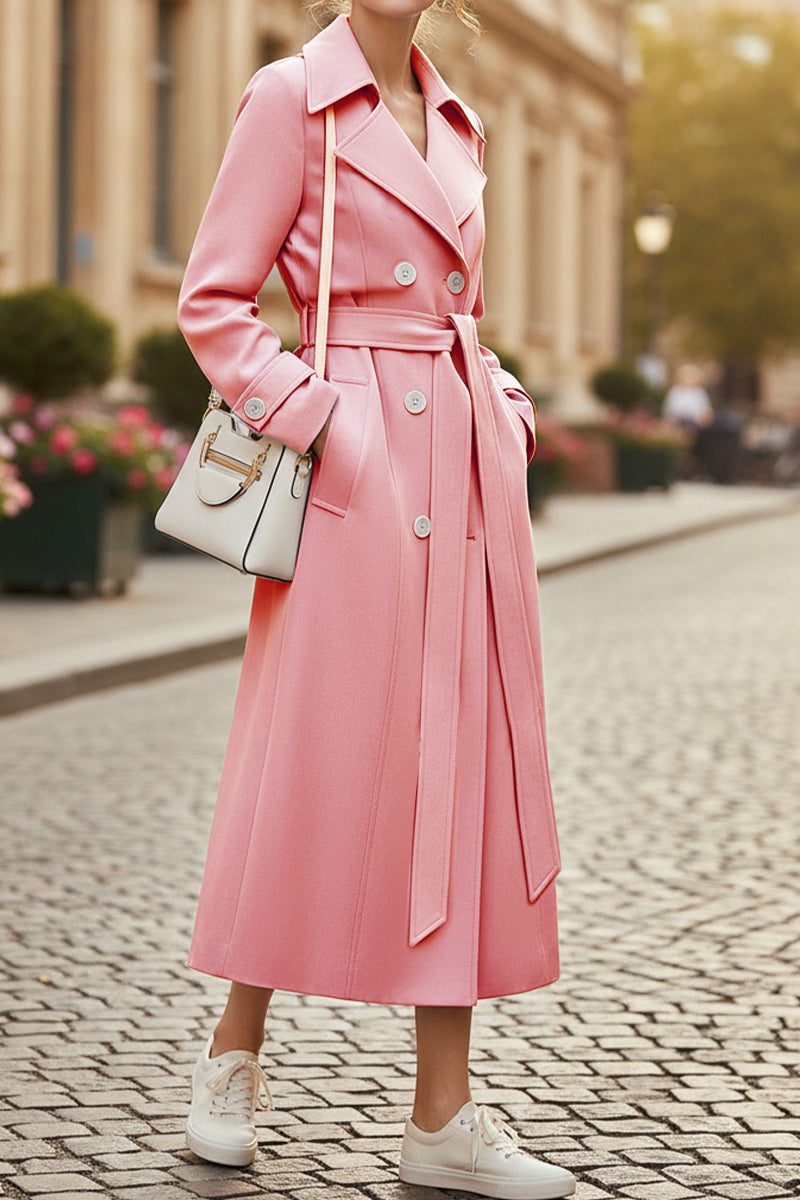 Pink timeless retro belted trench coat with double-breasted buttons and wide lapels on model walking outdoors
