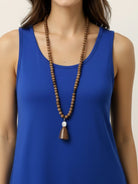 Woman wearing open-front three-piece co-ord with longline cardigan, tank top, and wide-leg trousers in lightweight knit fabric