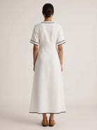 Woman wearing a knot-waist maxi dress with V-neckline and flowing skirt