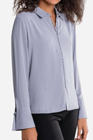 Bayam Blouse in soft lavender polyester with button-up front and long sleeves.