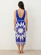 Deep-V swimsuit with ruched bust and waist, wide straps, low open back, high-cut leg, and sheer celestial print sarong wrap.