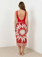 Deep-V swimsuit with ruched bust and waist, wide straps, low back, gold shell detail, and sheer celestial print sarong wrap