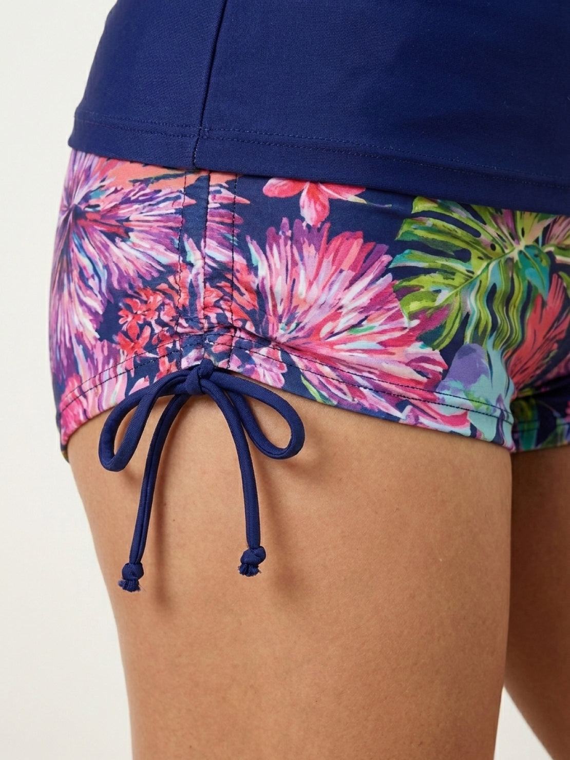 Tropical print rash guard set with long sleeves, high mock neckline, back zip, and boy-cut shorts with hip ties