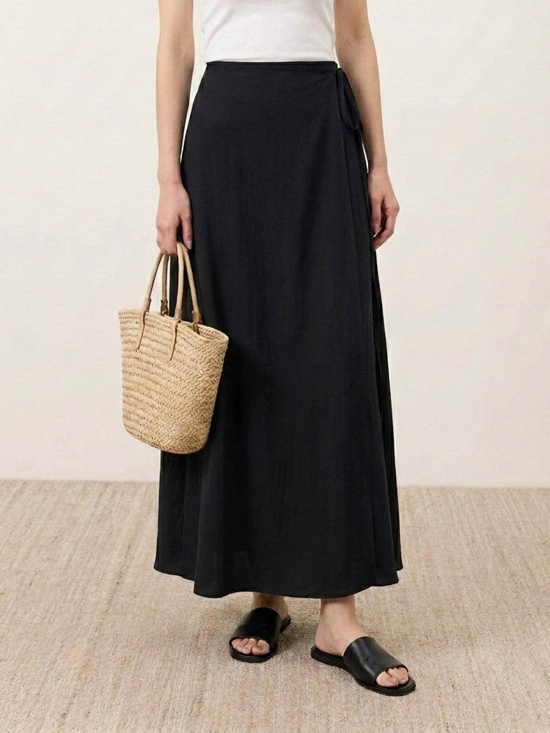 woman wearing asymmetrical wrap maxi skirt with side tie closure and asymmetric hem walking outdoors