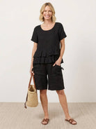 woman wearing cotton relaxed shorts and matching ruffle top two-piece co-ord set in soft linen texture