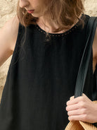 woman wearing sleeveless linen lyocell blend shift dress with round neckline and hand-stitched detail