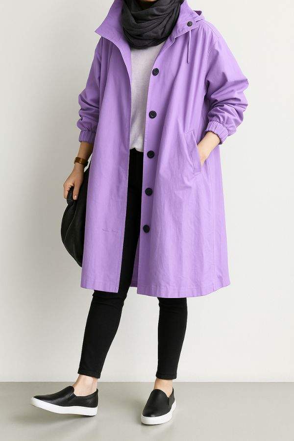 Water-resistant oversized purple hooded windbreaker rain jacket worn with black leggings and slip-on shoes