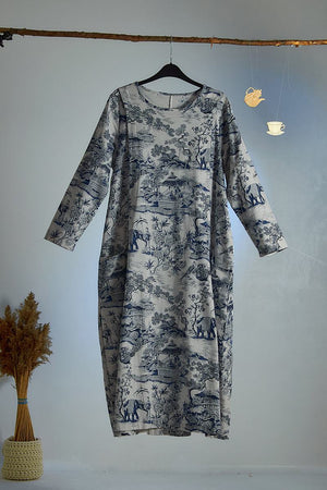 Japanese Porcelain Print cozy midi dress with blue motif, 3/4 sleeves, and functional pockets hanging on wooden rod.
