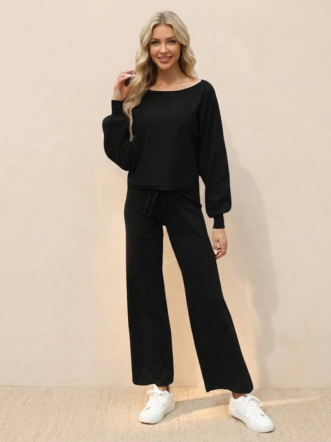 Woman wearing black round neck loose fit cozy two-piece set with wide-leg pants and white sneakers