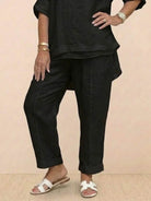 Black asymmetrical two-piece trouser set with rolled sleeves and tapered pants in breathable fabric