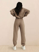Woman wearing a cotton-blended two-piece tracksuit with high collar and deep zipper in monochrome athleisure style