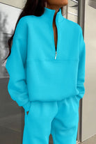 Woman wearing bright blue Classic Airplane Set two-piece tracksuit with high collar and zipper neck