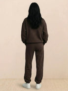 Woman wearing a cotton-blended two-piece tracksuit with high collar and zipper in a casual athleisure style