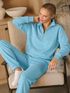 Woman wearing a stylish cotton-blended two-piece tracksuit with high collar and deep zipper in casual athleisure style