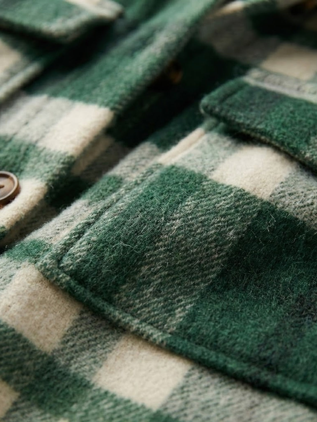 close-up of green and cream checkered comfy flannel classic button-down shirt pocket and buttons