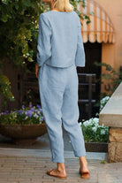 Back view of woman wearing a relaxed cotton-linen monochrome capsule set with longline top and wide-leg pants in light blue.