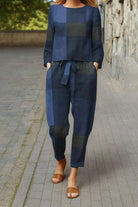 Woman wearing navy blue cotton-linen monochrome relaxed longline top and wide-leg pants set with brown sandals walking outdoors