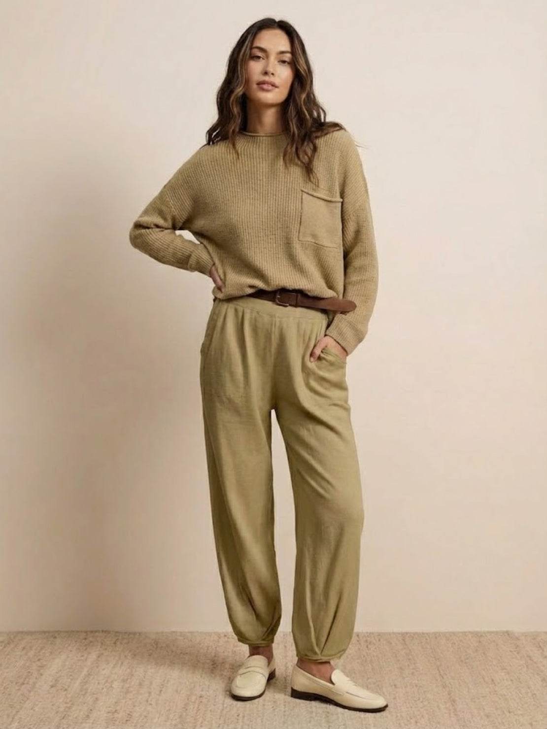 Woman wearing European minimalism relaxed khaki sweater top and trouser set, styled simply and elegantly