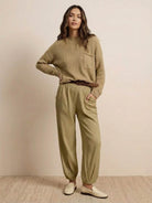 Woman wearing European minimalism relaxed khaki sweater top and trouser set, styled simply and elegantly