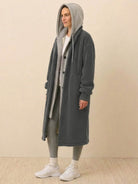 woman wearing grey everyday wear oversized sherpa long coat with hood and button closure
