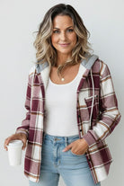Woman wearing Highland Plaid Shacket with hood, white tank top, and jeans, holding a coffee cup