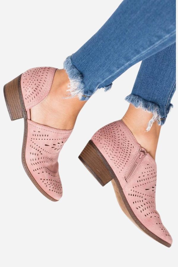 Pink laser cut western ankle boots with zipper and low wooden heel worn with frayed hem blue jeans