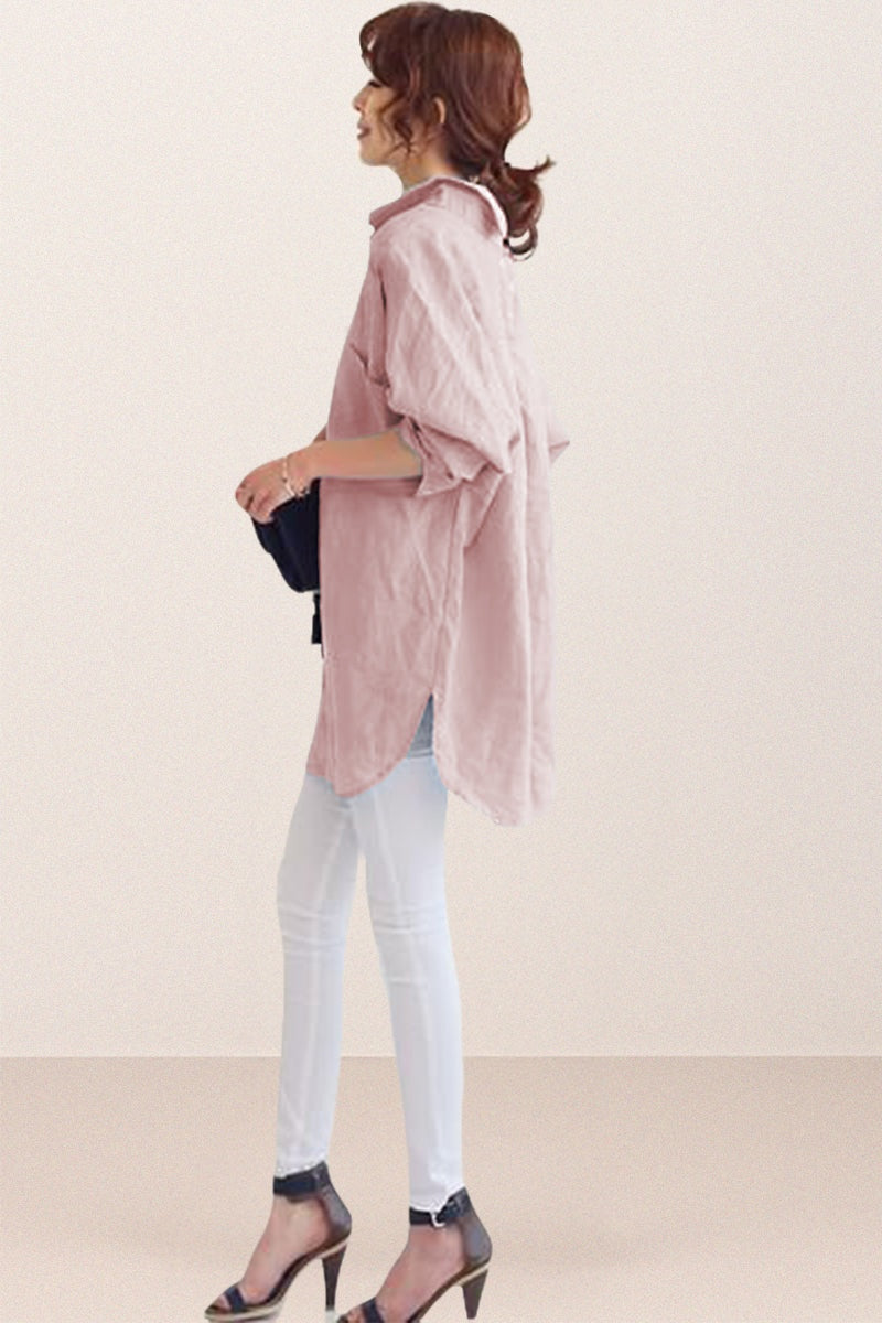 woman wearing oversized linen shirt in sun-washed pink with rolled sleeves and white pants