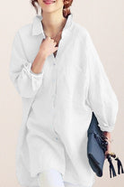 White oversized linen shirt with relaxed fit and button-down front, styled casually with rolled-up sleeves and a collar.