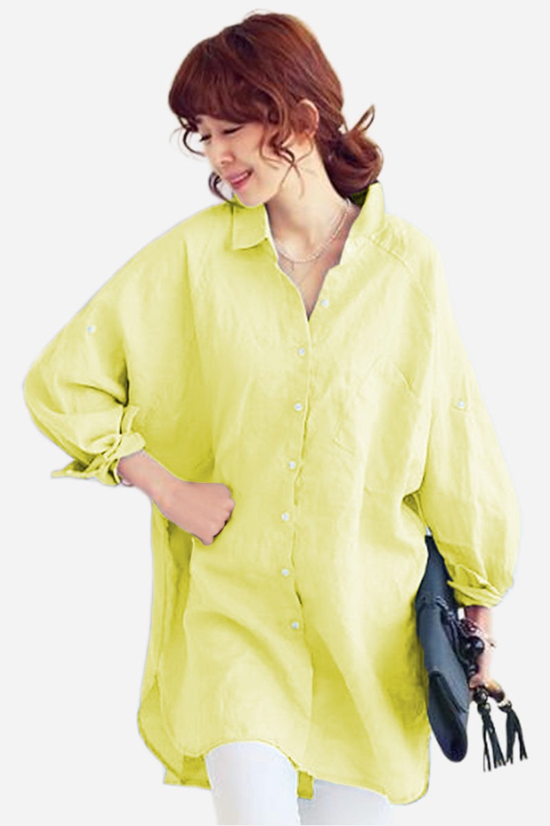 Woman wearing oversized linen shirt in light yellow with loose sleeves and button-down front