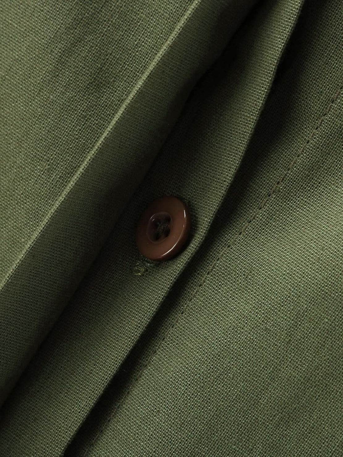 Close-up of oversized 100% cotton shirt fabric and button in olive green color