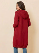 woman wearing oversized long zip sweatshirt hoodie in red with hood, back view