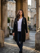 Woman wearing black oversized long zip sweatshirt hoodie with hood outdoors in urban setting