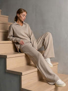 Woman wearing plush and preppy camel two-piece set with polo collar sitting on wooden stairs