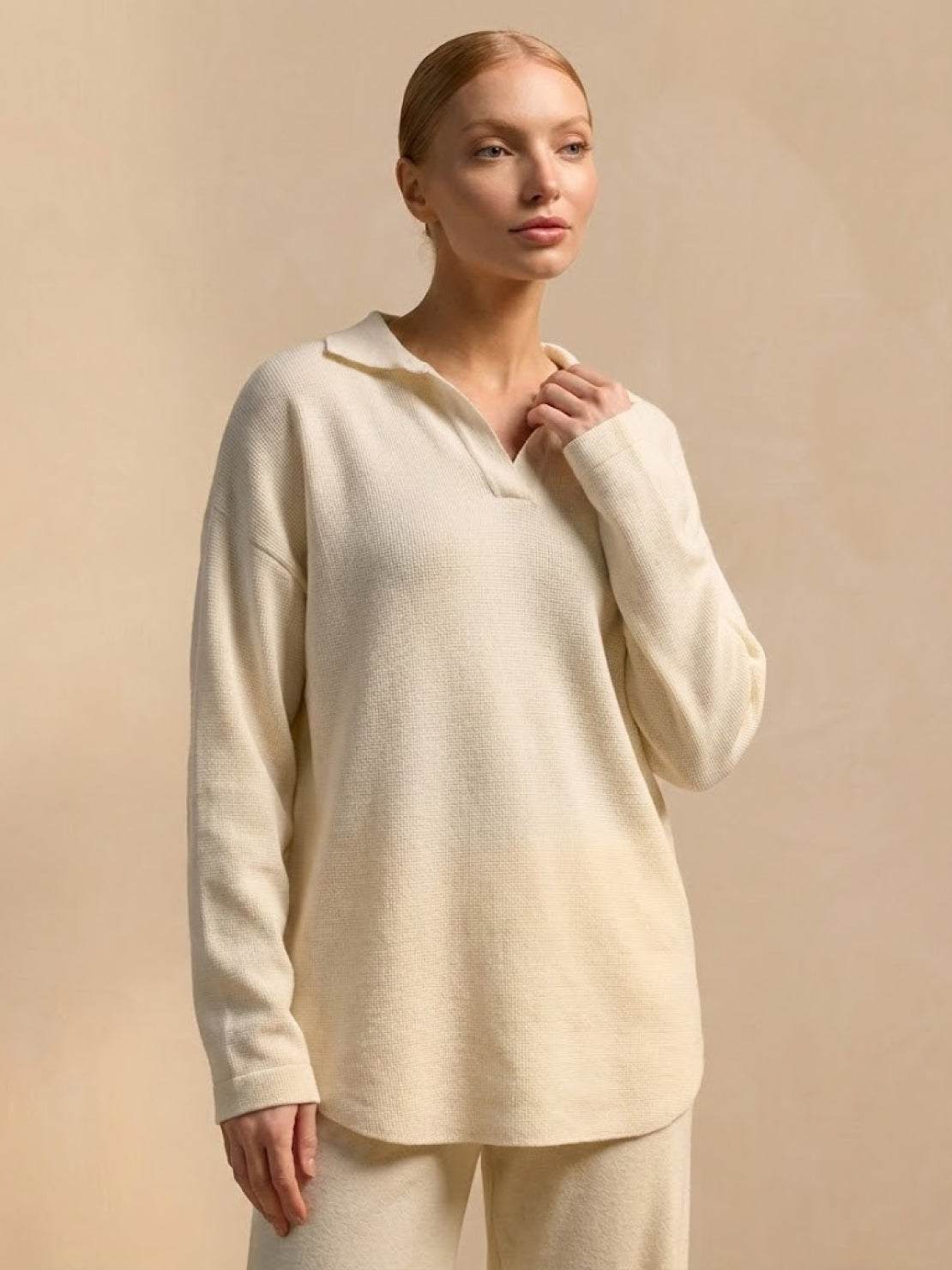 woman wearing plush and preppy camel two-piece set with long sleeves and polo collar against beige background