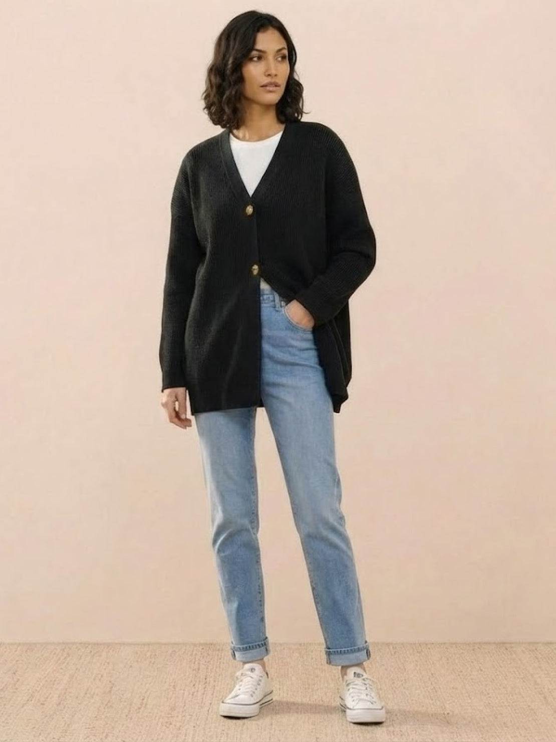 Relaxed fit oversized black knit cardigan with buttons worn over white top and blue jeans