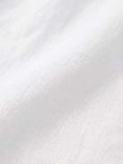 Close-up of soft white relaxed loose breathable linen fabric texture