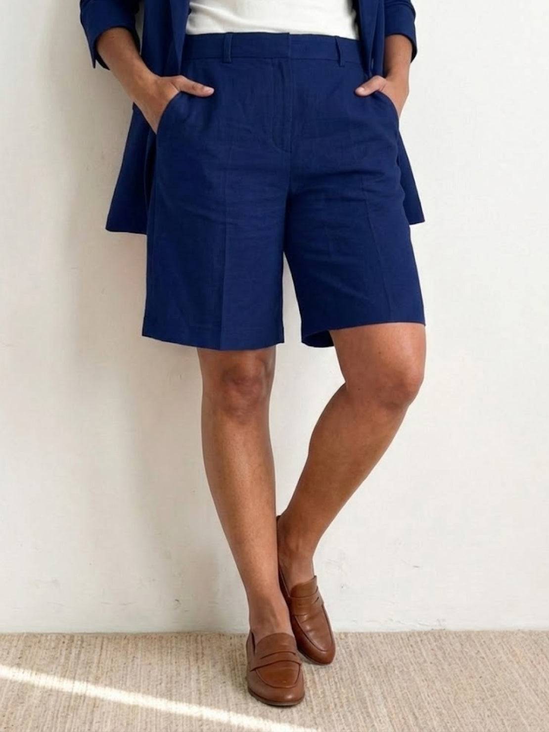 Woman wearing a stylish blazer and shorts two-piece set in vibrant blue color