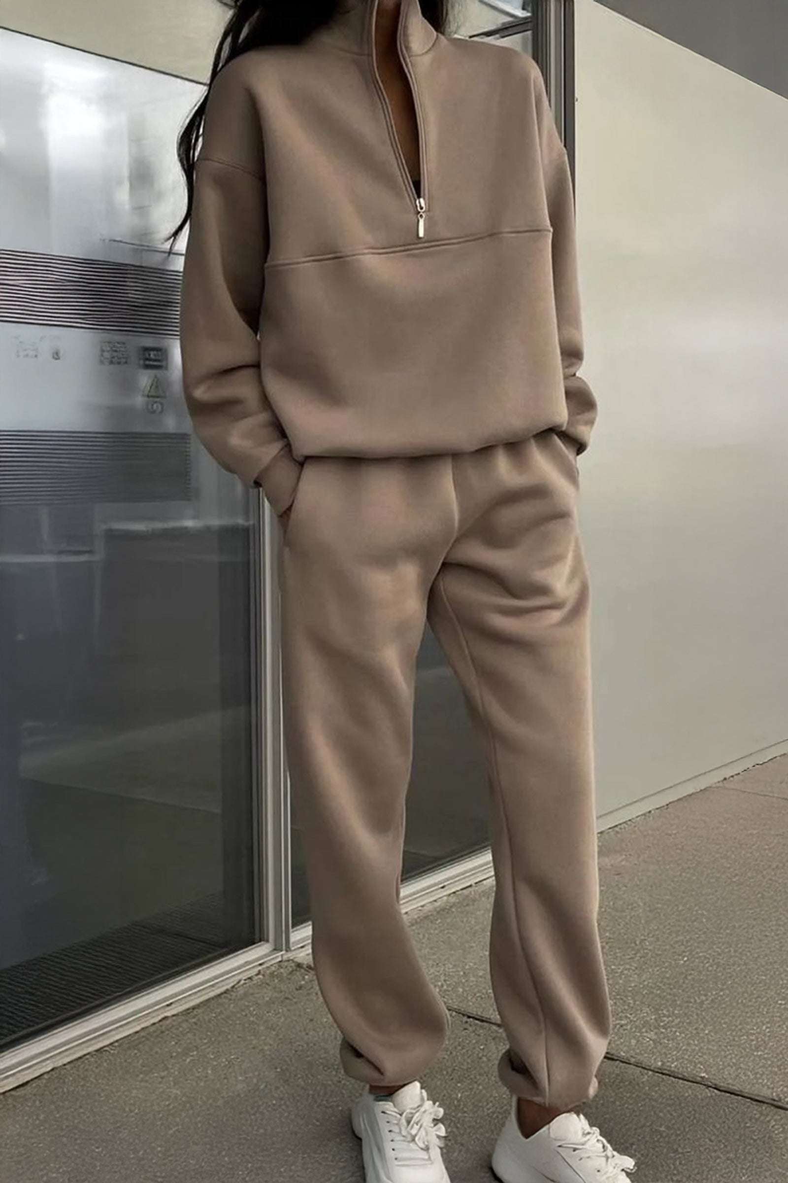 Neutral tone cotton blend tracksuit with zip neckline and stretch waistband, styled casually with white sneakers.