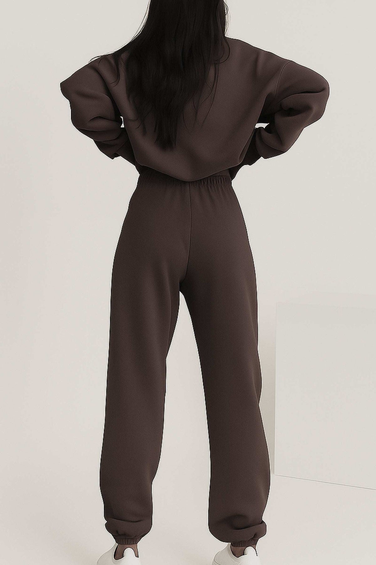 Back view of woman wearing brown cotton blend tracksuit with elastic waistband and cuffs