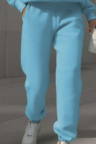 Light blue cotton blend tracksuit pants with stretch waistband and cuffs, styled with white sneakers.