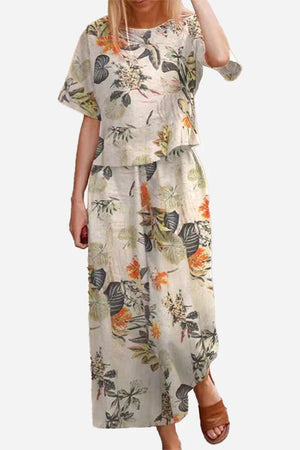 Woman wearing a floral print loose fit co-ord set with wide short sleeves top and wide-leg bottoms paired with brown sandals