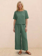 Woman wearing green loose fit co-ord set with wide-leg pants and short sleeve top