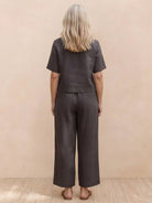 Woman wearing a loose fit co-ord set with soft-tailored top and wide-leg bottoms in a relaxed style